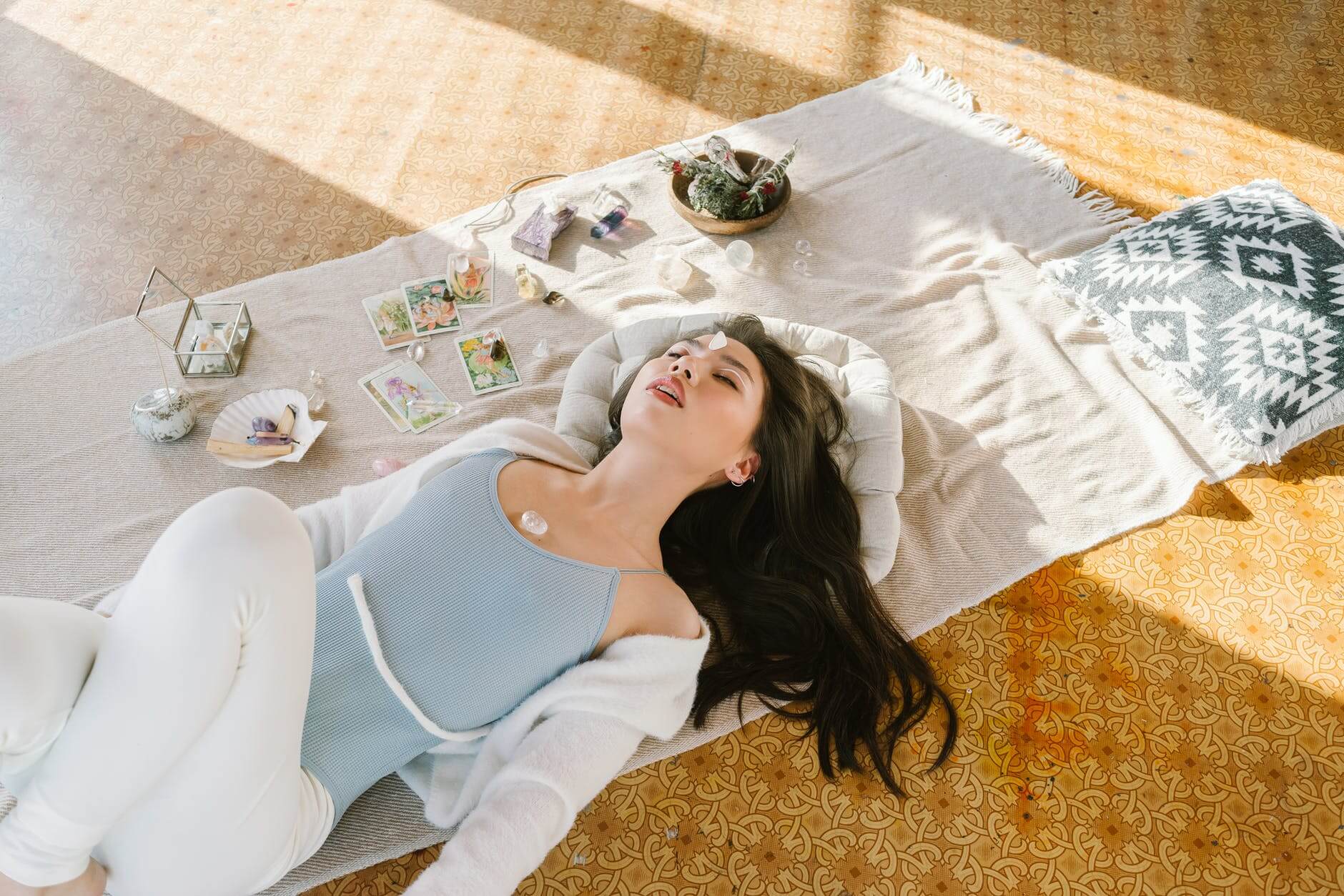 serene asian woman lying with chakra stone on chest