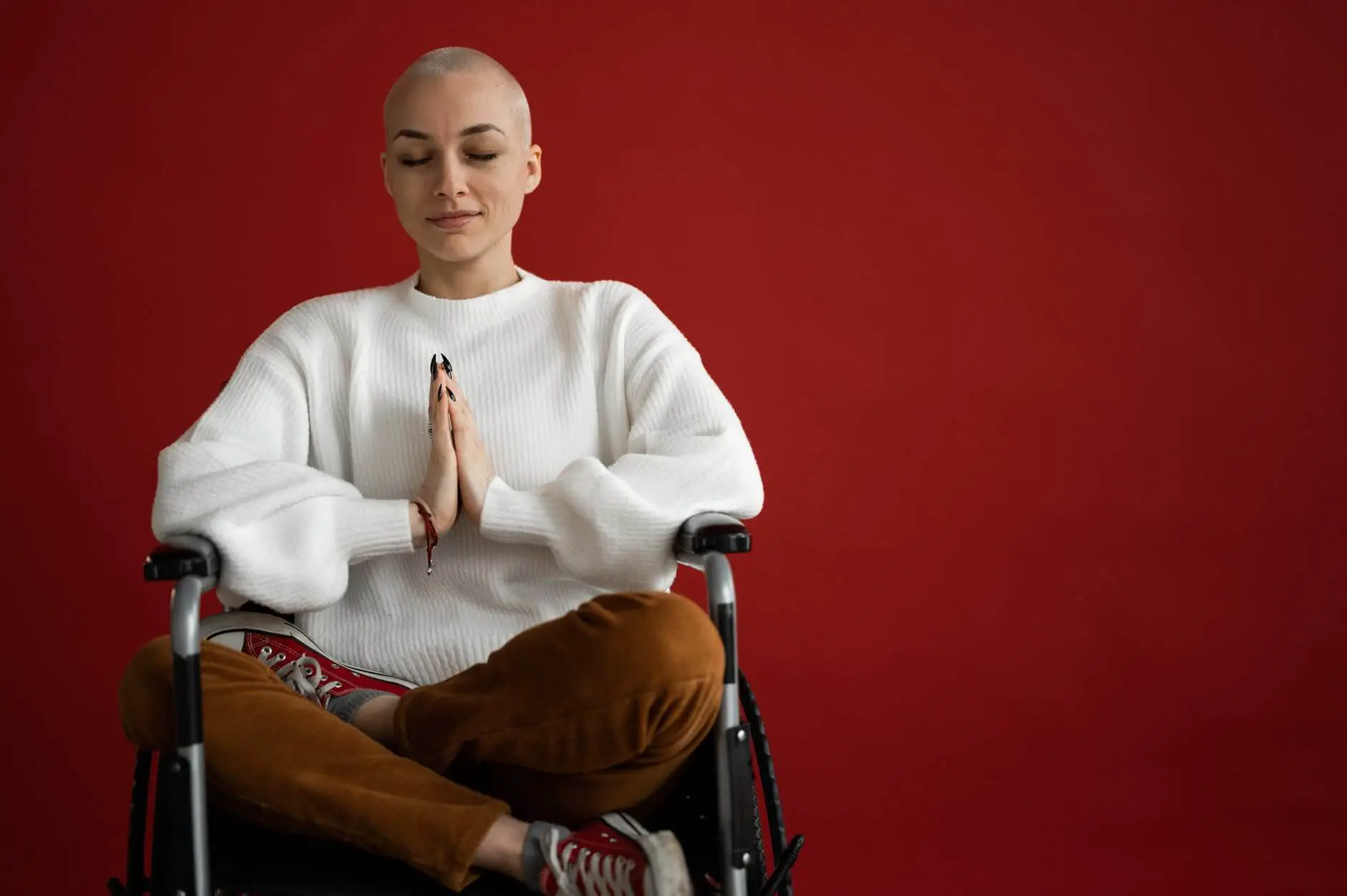mindful woman meditating with closed eyes in wheelchair